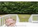 Outdoor deck featuring a woven chair with a floral pillow and a lush green lawn at 657 Lakeview Dr, Stem, NC 27581