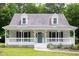 Charming exterior view of home featuring a spacious porch and lovely landscaped yard at 657 Lakeview Dr, Stem, NC 27581