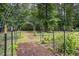 Idyllic garden featuring a metal arch trellis with various plants and a well-maintained landscape at 657 Lakeview Dr, Stem, NC 27581