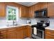 Charming kitchen featuring stainless steel appliances, wood cabinets, and a bright window over the sink at 657 Lakeview Dr, Stem, NC 27581