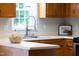 A well-lit kitchen with wooden cabinets, modern fixtures, and white countertops at 657 Lakeview Dr, Stem, NC 27581