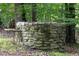 Historic stone well feature in a wooded area adding unique character to the landscape at 657 Lakeview Dr, Stem, NC 27581