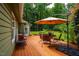 Spacious wooden deck with a dining set and umbrella, ideal for outdoor entertaining at 69 Margaret Pl, Chapel Hill, NC 27516