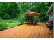 Relaxing outdoor deck with an umbrella-covered table and chairs overlooking the landscaped backyard at 69 Margaret Pl, Chapel Hill, NC 27516