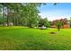 Well-maintained backyard with mature trees and lush green lawn at 6909 Hickory Dr, Raleigh, NC 27603