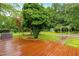 Wooden patio with lush backyard, green trees and green grass at 6909 Hickory Dr, Raleigh, NC 27603