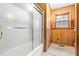 Bathroom with frosted glass enclosed shower, vintage wall decor, and wood paneling at 6909 Hickory Dr, Raleigh, NC 27603