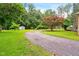 Long driveway leading to a house surrounded by green grass and trees at 6909 Hickory Dr, Raleigh, NC 27603