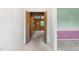 Hallway with wood-paneled walls leading to another room, featuring louvered doors at 6909 Hickory Dr, Raleigh, NC 27603