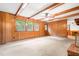 Spacious living room with wood paneling, carpet flooring, and natural lighting at 6909 Hickory Dr, Raleigh, NC 27603