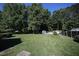 Expansive backyard with lush green grass, mature trees, and a shed, perfect for outdoor activities at 70 Glen Oaks Drive Dr, Youngsville, NC 27596