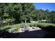 Lush backyard featuring a stone patio, fire pit, and mature trees for privacy at 70 Glen Oaks Drive Dr, Youngsville, NC 27596