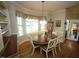 Elegant dining area with a dark wood table, white chairs, and natural light from a bay window at 70 Glen Oaks Drive Dr, Youngsville, NC 27596