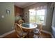Charming dining area with a round table, wood chairs, and views of the yard at 70 Glen Oaks Drive Dr, Youngsville, NC 27596