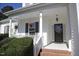 Close up of a charming covered porch with flowers, white columns and a decorative front door at 70 Glen Oaks Drive Dr, Youngsville, NC 27596
