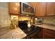 Updated kitchen with stainless steel appliances, granite countertops, and wood cabinets at 70 Glen Oaks Drive Dr, Youngsville, NC 27596