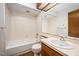 A bathroom featuring a bathtub with a shower, a toilet and a vanity with sink and a large mirror at 73 Stoneridge Rd, Durham, NC 27705