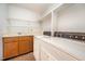 Laundry room with washer, dryer, sink, storage cabinets and open shelving above at 73 Stoneridge Rd, Durham, NC 27705