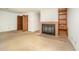 Cozy living room corner with a brick fireplace, built-in shelving, and views of bi-fold closet doors at 73 Stoneridge Rd, Durham, NC 27705