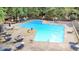 Aerial shot of a large community pool with lounge chairs, tables, and shady trees at 73 Stoneridge Rd, Durham, NC 27705