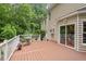 Spacious back deck overlooks private, wooded backyard and features white railings and seating area at 7811 Still Crossing Rd, Chapel Hill, NC 27516