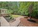 Backyard with lush landscaping, a fire pit area, and a pathway leading to a serene outdoor space at 7811 Still Crossing Rd, Chapel Hill, NC 27516