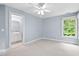 Bright bedroom with ensuite bathroom, ceiling fan and verdant backyard views at 7811 Still Crossing Rd, Chapel Hill, NC 27516