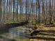 A serene creek runs through the wooded lot, offering a peaceful and natural setting at 7811 Still Crossing Rd, Chapel Hill, NC 27516