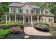 Charming two-story home featuring a welcoming front porch and lush, manicured landscaping at 7811 Still Crossing Rd, Chapel Hill, NC 27516