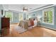 Spacious main bedroom with hardwood floors, tray ceilings, ceiling fan and windows overlooking the backyard at 7811 Still Crossing Rd, Chapel Hill, NC 27516
