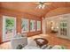 Bright sunroom boasts wood ceiling, multiple windows, access to outdoor deck and open entry to the living room at 7811 Still Crossing Rd, Chapel Hill, NC 27516