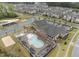 Expansive aerial view of community amenities including pool, playground, tennis courts, sand volleyball, and pond at 803 Courting St, Apex, NC 27523