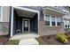 Inviting covered front porch with dark siding, stone details, and craftsman trim at 803 Courting St, Apex, NC 27523