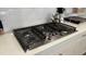 Close up on the gas cooktop featuring stainless steel accents and white quartz countertops at 803 Courting St, Apex, NC 27523