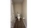 Small half bathroom with a white toilet, beige walls, dark hardwood floors, and a white door at 803 Courting St, Apex, NC 27523