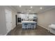 Modern kitchen with stainless steel appliances, an island with bar stools, and white cabinetry at 803 Courting St, Apex, NC 27523