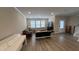 Open-concept living room with hardwood floors, neutral paint, and plenty of natural light from large windows at 803 Courting St, Apex, NC 27523