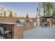 Outdoor kitchen area with grills, countertops, gazebo, and seating surrounded by a brick wall at 803 Courting St, Apex, NC 27523