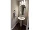 Cozy half bathroom showcasing a pedestal sink, oval mirror, and neutral walls, adding convenience for guests at 803 Courting St, Apex, NC 27523