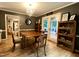 Open dining room featuring hardwood floors, a chandelier, and access to a screened-in back porch at 8620 Brookdale Dr, Raleigh, NC 27613