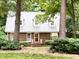Charming brick home featuring a well-manicured lawn and complemented by mature trees at 8620 Brookdale Dr, Raleigh, NC 27613