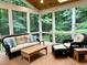 Inviting sunroom with wicker furniture, views of the trees, and hardwood floors at 8620 Brookdale Dr, Raleigh, NC 27613