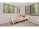 A bedroom is well lit by two large windows and includes carpet and a white nightstand at 8821 Oconee Ct, Chapel Hill, NC 27516