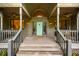 Inviting front porch with a teal door, seating area, and stylish exterior lighting at 8821 Oconee Ct, Chapel Hill, NC 27516