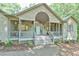 Inviting front porch with an arched entryway, swing, and beautiful landscaping at 8821 Oconee Ct, Chapel Hill, NC 27516