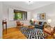 Cozy living room featuring hardwood floors, stylish decor, and natural light from large windows at 8821 Oconee Ct, Chapel Hill, NC 27516