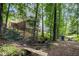 Picturesque backyard featuring a small creek, bridge, Adirondack chairs, and a tranquil wooded setting at 905 Balmoral Dr, Cary, NC 27511