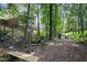 Lush wooded backyard featuring a creek with bridge and Adirondack chairs, offering a peaceful retreat at 905 Balmoral Dr, Cary, NC 27511