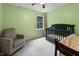 Welcoming Bedroom with a comfortable chair and a crib, filled with natural light at 905 Balmoral Dr, Cary, NC 27511