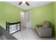 Bright bedroom with soft green walls, gray chair, changing table and neutral carpet at 905 Balmoral Dr, Cary, NC 27511